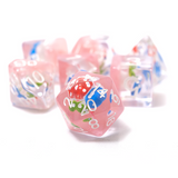 Set of pink dice with blue and green numbers on a white background