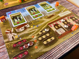 Board game with farm-themed layout and cards on a wooden surface