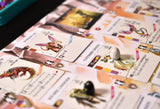 Close-up of a board game with colorful cards featuring images and text.