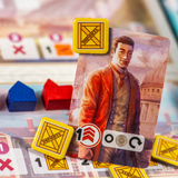 Card with a person in an orange coat and vintage clothing, surrounded by game pieces and cards on a blurred background.