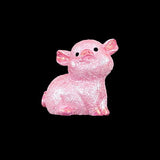 Pink glittery pig figurine on a black background
