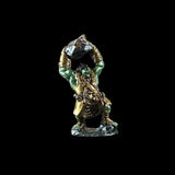 Metallic figurine of a warrior carrying a rock on his head against a black background