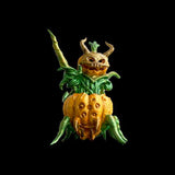Decorative pumpkin with a face and green leaves on a black background