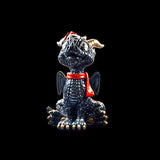 Small dragon figurine with a red scarf on a black background