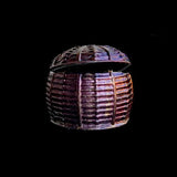Decorative woven basket with a lid on a black background