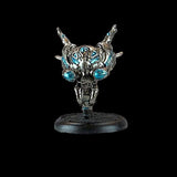 Metallic figurine with blue gemstones on a black background