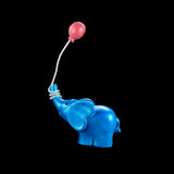 Blue elephant toy with a pink balloon on a black background