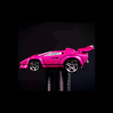 Pink toy car on a reflective black surface with a dark background