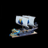 Model of a ship with white sails and gold and blue accents on a black background