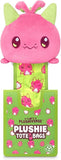 Pink plushie with green accents on a green tote bag with Plushiverse branding.