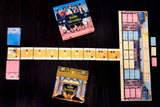 Board game components including cards and a map on a dark surface