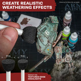 Model miniatures being worked on with a brush, surrounded by paint bottles and text about creating realistic weathering effects.