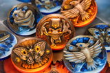 Collection of decorative buttons with animal designs on a reflective surface.