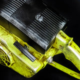Close-up of a yellow power tool with a black component on a dark background