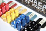 Colorful dice and dominoes set on a white surface with a decorative background.