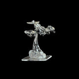 Metallic figurine of a spaceship on a clear stand against a black background