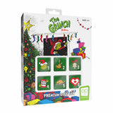 The Grinch Disney Premium Dice Set in its original retail packaging, featuring a white box decorated with Christmas illustrations and six green square dice showing holiday-themed images.