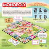 Monopoly game set with Strawberry Shortcake theme, including board, tokens, and currency.