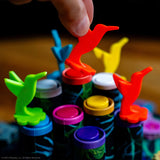 Colorful toy bottles with caps being held by a hand against a blurred background