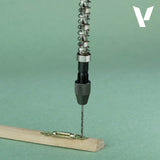 Metal spring mechanism on a wooden block with a green background