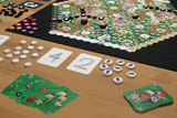 Board game setup with colorful board, cards, and pieces on a wooden table.