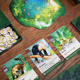 Board game components including cards and a board on a wooden surface