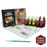 Art supplies set with 'John Blanche' book, paint bottles, and a pen on a white background