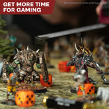Two warrior figurines with armor and weapons on a gaming table with dice, surrounded by game accessories.