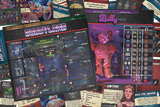 Collection of board game components including cards and a board with character and monster stats.