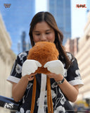 Person holding a plush toy with a cityscape background