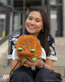 Person holding a plush toy with a blurred background