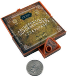 A vintage-style Ouija board set with an orange-brown wooden board, matching planchette, and a coin shown below for scale on a white background.