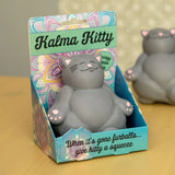 Gray cat-shaped toy in a colorful 'Kalma Kitty' packaging on a wooden surface.