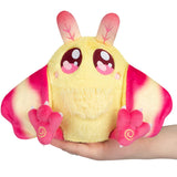 Plush toy moth with yellow body and pink wings held in a hand on a white background