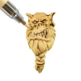 Paint marker being applied to a mini monster head on a white background