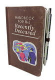 Notebook with 'Handbook for the Recently Deceased' cover and pen attached