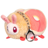 Plush keychain shaped like a cartoonish creature with a pink bow on a white background