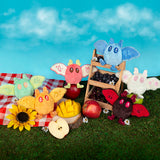 Colorful plush toys on a grassy area with a blue sky background