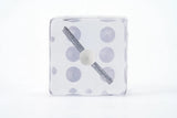 Square clock with polka dot pattern on a white background