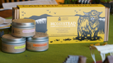 Cantrip Candles Homestead collection with packaging featuring a bull illustration on a green surface.