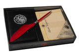 Decorative set with red feather pen, black book, and paper in a box