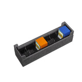 Black rectangular tray with compartments holding small colored boxes on a white background