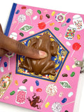 Chocolate frog on a pink notebook with candy-themed design