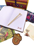 Open notebook with a gold pen, Quidditch badge, and game cards on a white surface.