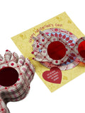 Decorative plates with heart designs on a yellow card with Valentine's Day text.