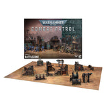 Warhammer 40k Battlezone Combat Patrol miniatures and terrain set displayed on a tan tabletop with the product box behind it, on a white background.
