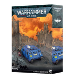 Warhammer 40,000 Space Marines Rhino miniatures figure box, showing blue armored vehicle models on a ruined city scene with an orange smoky sky.