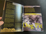 Open book with text and a picture of a dog labeled 'Dog Pit' on a dark surface.