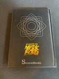 Black book with gold and white text and design on a gray background