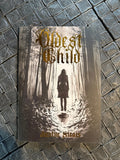 Book titled 'Oldest Child' by Justin Scott on a textured surface